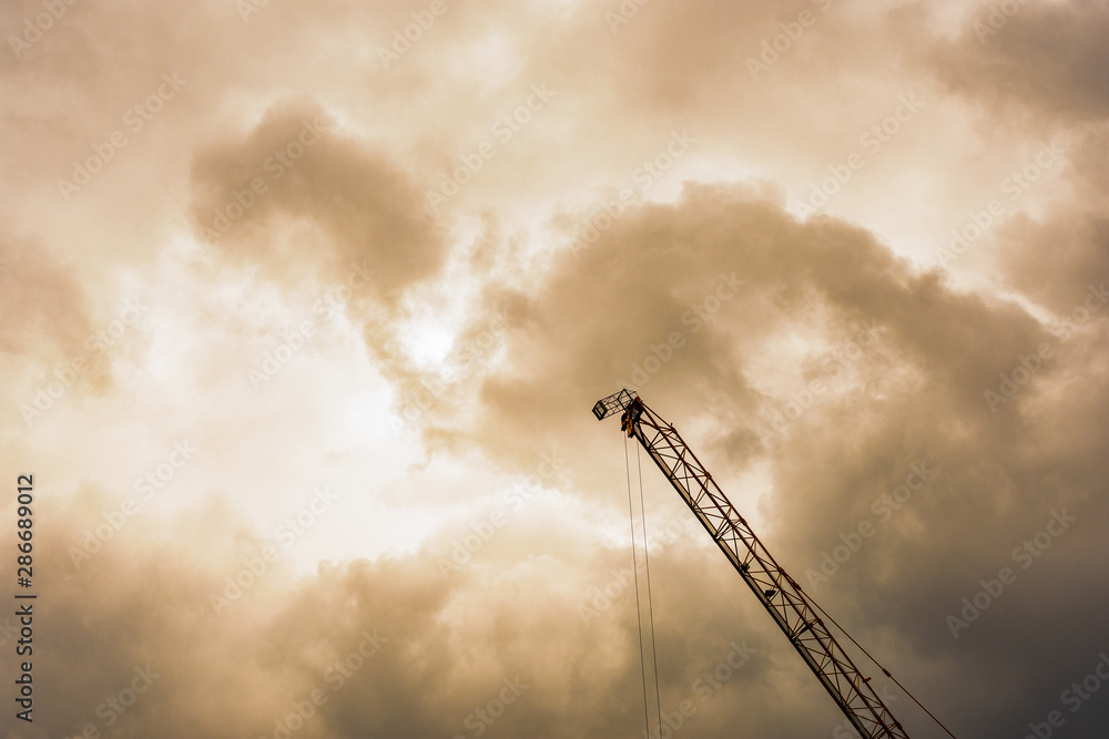 Hydraulic Mobile Crane against the elephant shaped cloud during sunset. Hydraulic Mobile Crane against the elephant shaped cloud during sunset.