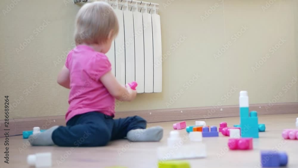 Little children playing with colorful construction plastic blocks at home Little children playing with colorful construction plastic blocks at home
