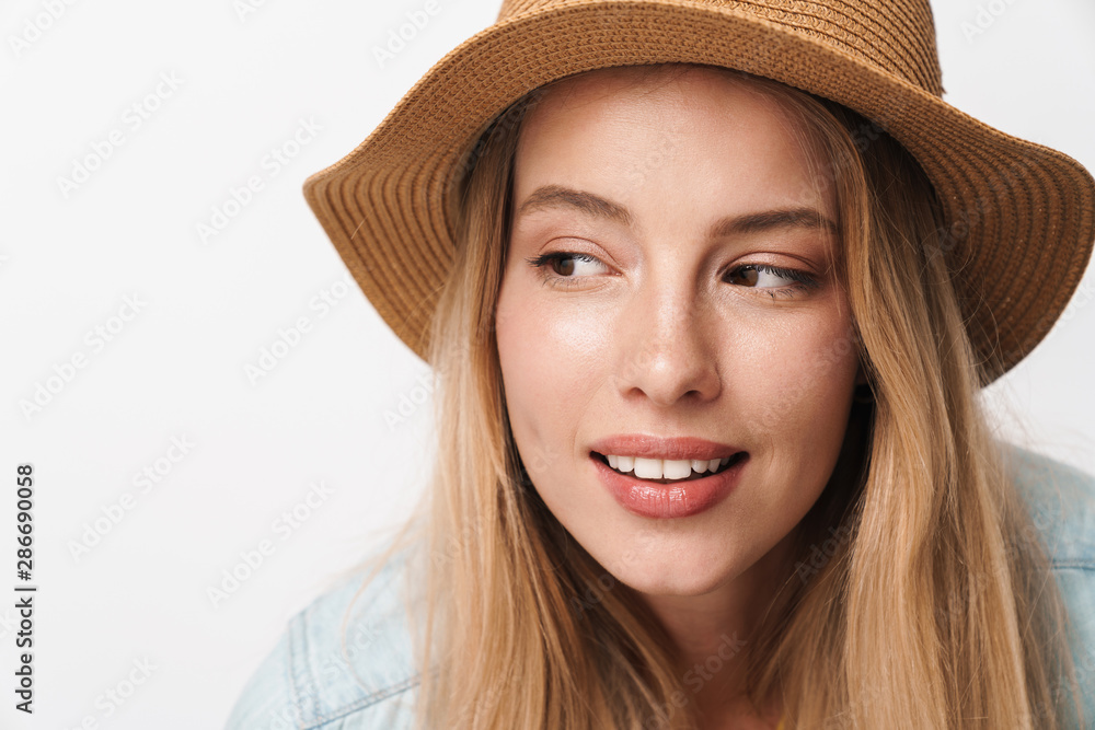 Flirty amazing young pretty woman wearing hat posing isolated over white wall background looking at copyspace.