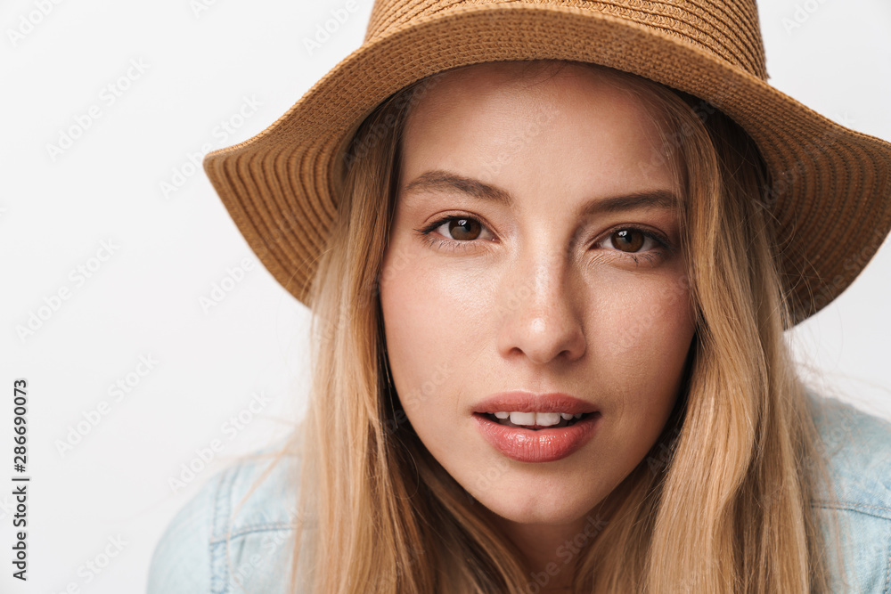 Serious amazing young pretty woman wearing hat posing isolated over white wall background. Serious amazing young pretty woman wearing hat posing isolated over white wall background.