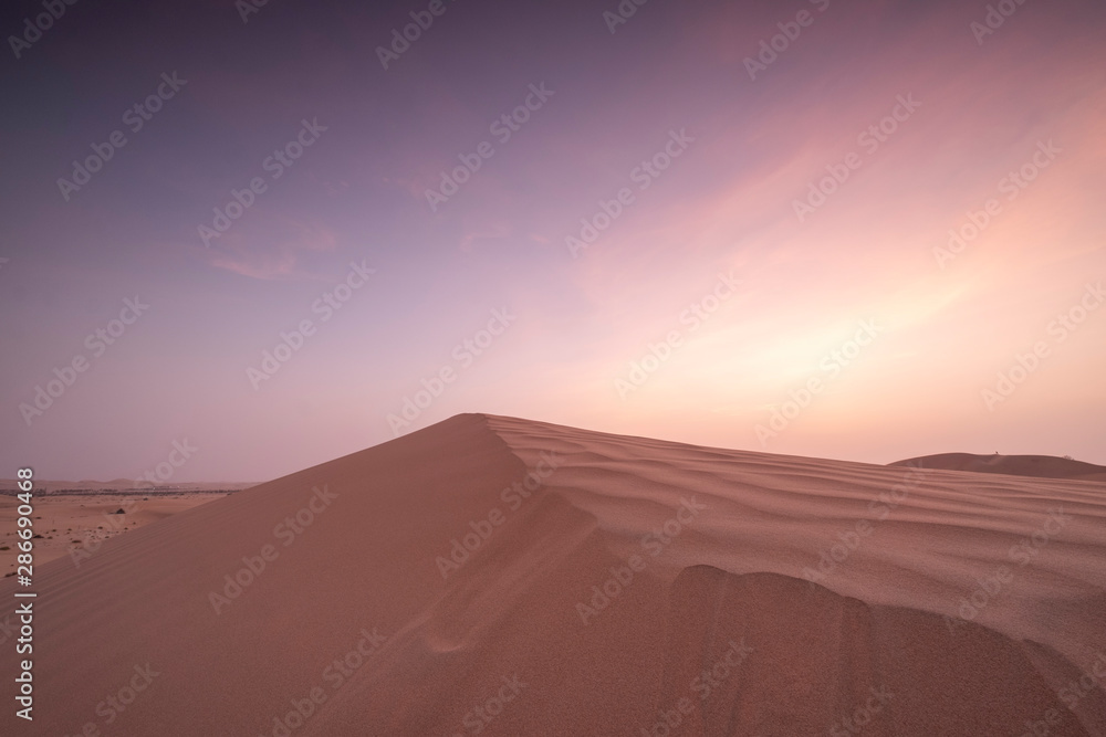 Sun set in dessert outside of Abu Dhabi with pink and red sky UAE Sun set in dessert outside of Abu Dhabi with pink and red sky UAE