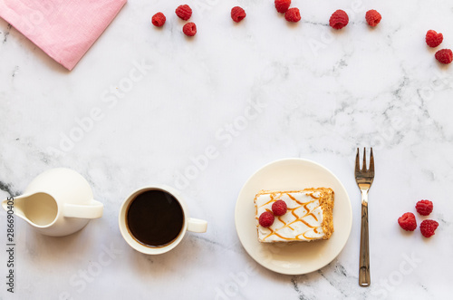 Dessert with raspberries and cup of black coffee on a marble background. Top view. Copy space. Horizontal orientation.