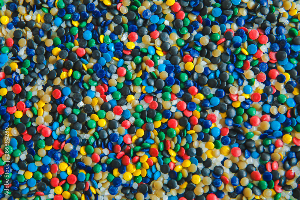 Naklejka Industrial colorful Polymeric dye. Plastic pellets. Colorant for plastics. Pigment in the plastic polyethylene granules background texture.