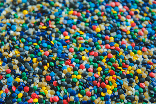 Industrial colorful Polymeric dye. Plastic pellets. Colorant for plastics. Pigment in the plastic polyethylene granules background texture.