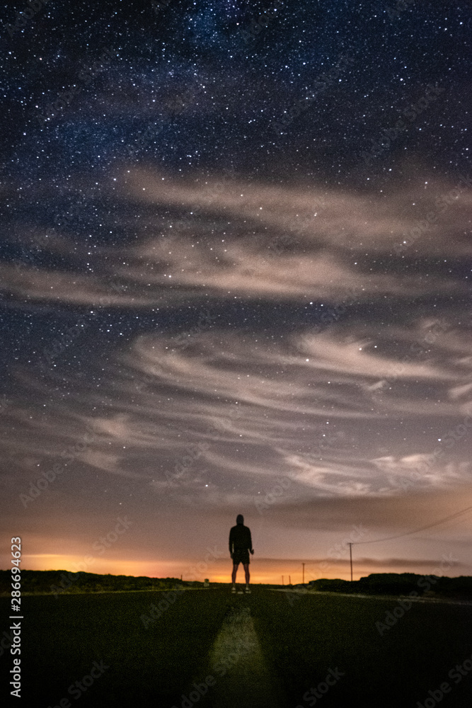 Silhouette of a man at night, under the stars in Sagres, Portugal