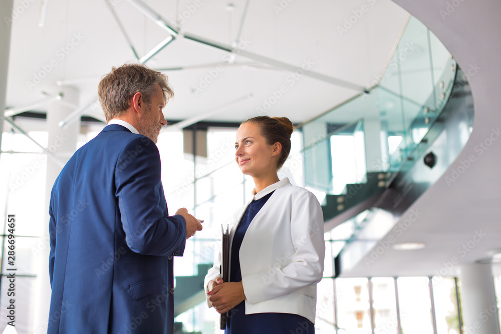 Businessman and young businesswoman discussing at new office