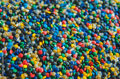 Industrial colorful Polymeric dye. Plastic pellets. Colorant for plastics. Pigment in the plastic polyethylene granules background texture.