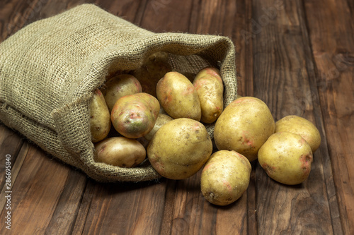 potatoes in a bag on a wooden surface