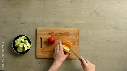 cutting tomatoes on a board top view