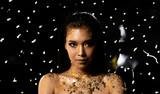 Fashion Young Asian Woman eyes brown black straight hair beautiful make up fashion decorate with Golden Foil or Gold leaf all over neck and shoulder. Studio Lighting dark Background star holes smoke