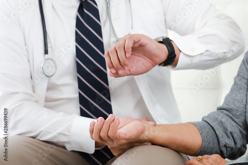 Asian young Doctor talking with Senior woman in hospital