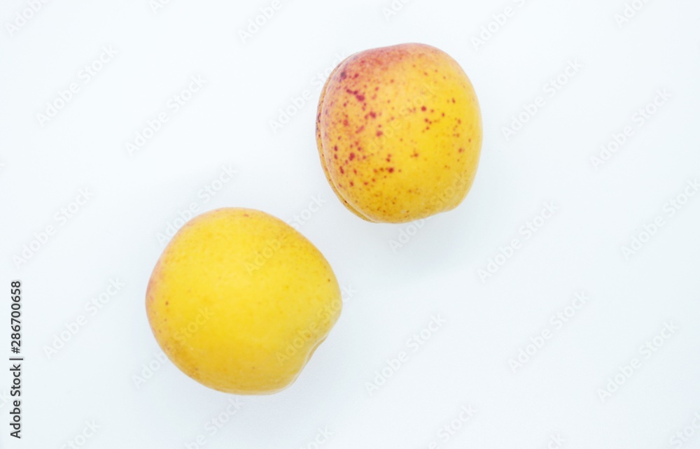 Delicious juicy apricots are located on a white background