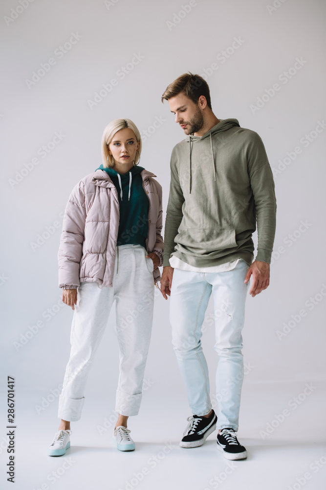 full length view of stylish blonde girl and bearded man on grey full length view of stylish blonde girl and bearded man on grey