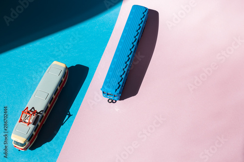 Models of a Russian metro car and tram on a pink background with sunlight. Russian transport. Toy models
