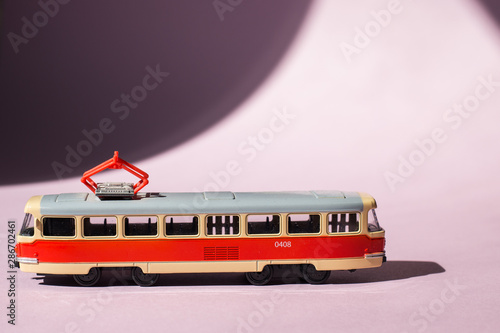 Model of a Russian tram on a pink background with sunlight. Russian transport. Toy model
