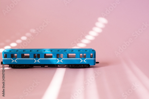 Model of a Russian metro car on a pink background with sunlight. Russian transport. Toy model