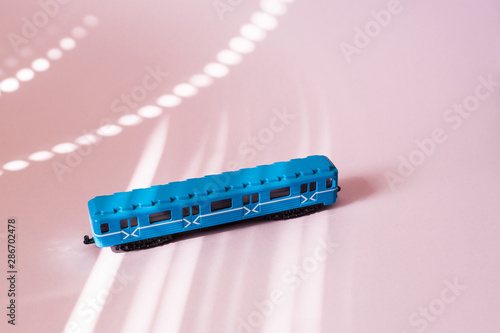 Model of a Russian metro car on a pink background with sunlight. Russian transport. Toy model
