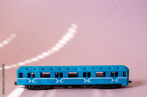 Model of a Russian metro car on a pink background with sunlight. Russian transport. Toy model