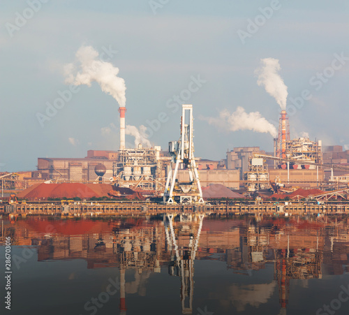 Landscape of industry with reflection on water.