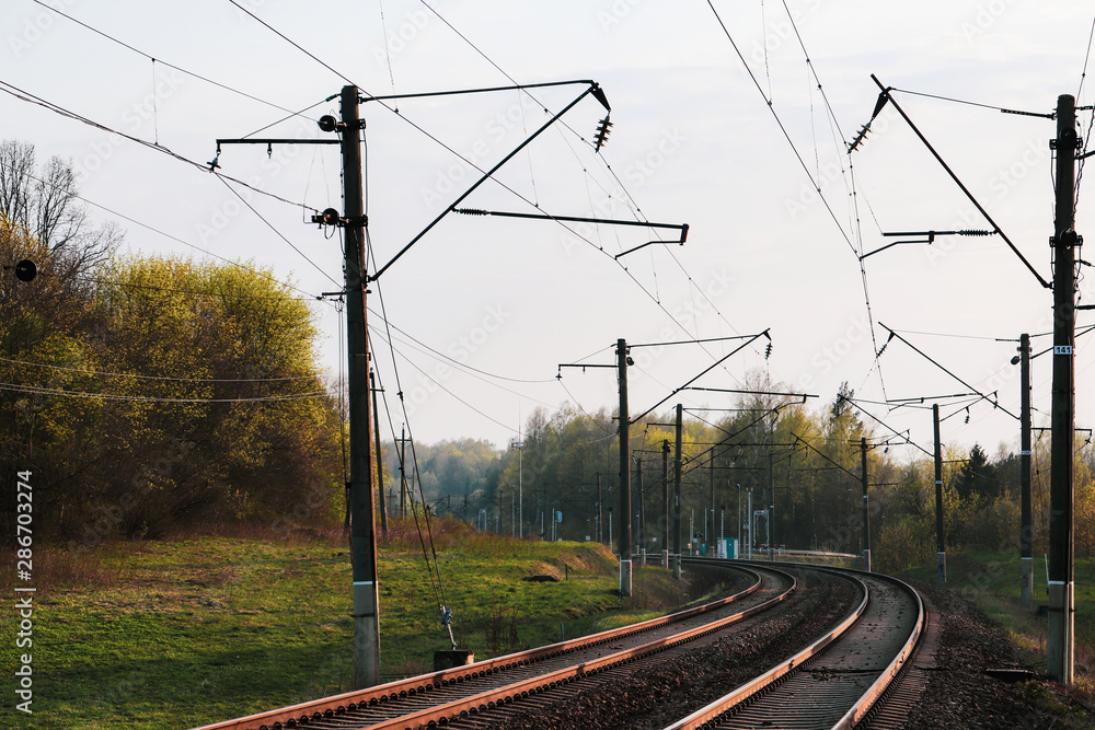 Double electrified railway line with automatic passage in the background.