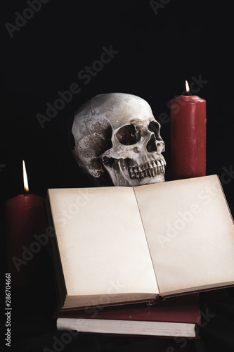 Human skull with book mock-up and candles