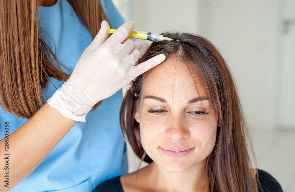Naklejka premium cosmetic injection in the clinic in the hair