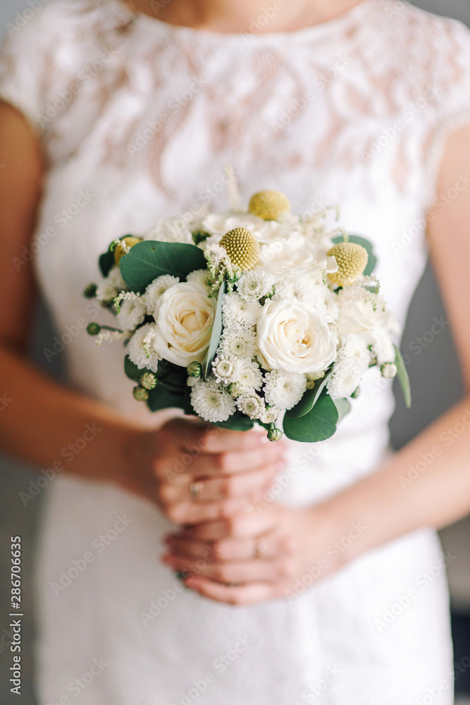 Wedding bouquet in the hands of the bride close-up. Wedding flowers.