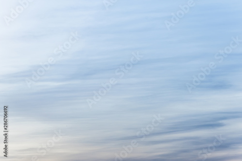 sunset background. sky with soft and blur pastel colored clouds. sunshine through the gradient cloud on the beach resort. nature. sunrise.  peaceful morning © flowertiare