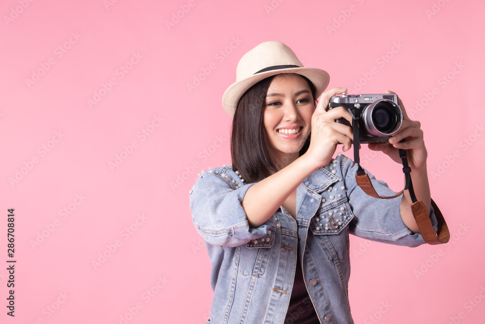 Tourist woman in summer casual clothes.Asian Smiling woman .Passenger traveling abroad to travel on pink background.She going to summer vacation.Travel trip funny with camera. Tourist woman in summer casual clothes.Asian Smiling woman .Passenger traveling abroad to travel on pink background.She going to summer vacation.Travel trip funny with camera.