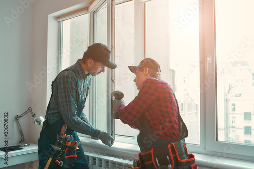 Tableau sur toile Provading best service. Men are installing a window