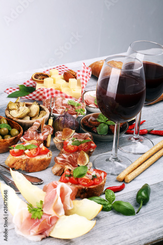 Italian antipasti wine snacks set. Cheese variety  Mediterranean olives  Prosciutto di Parma  tomatoes  artichokes