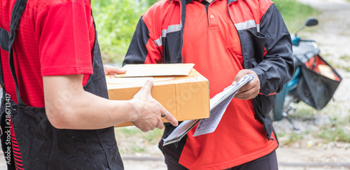Young recipient man's hand accepting boxes from delivery man. Courier service concept.