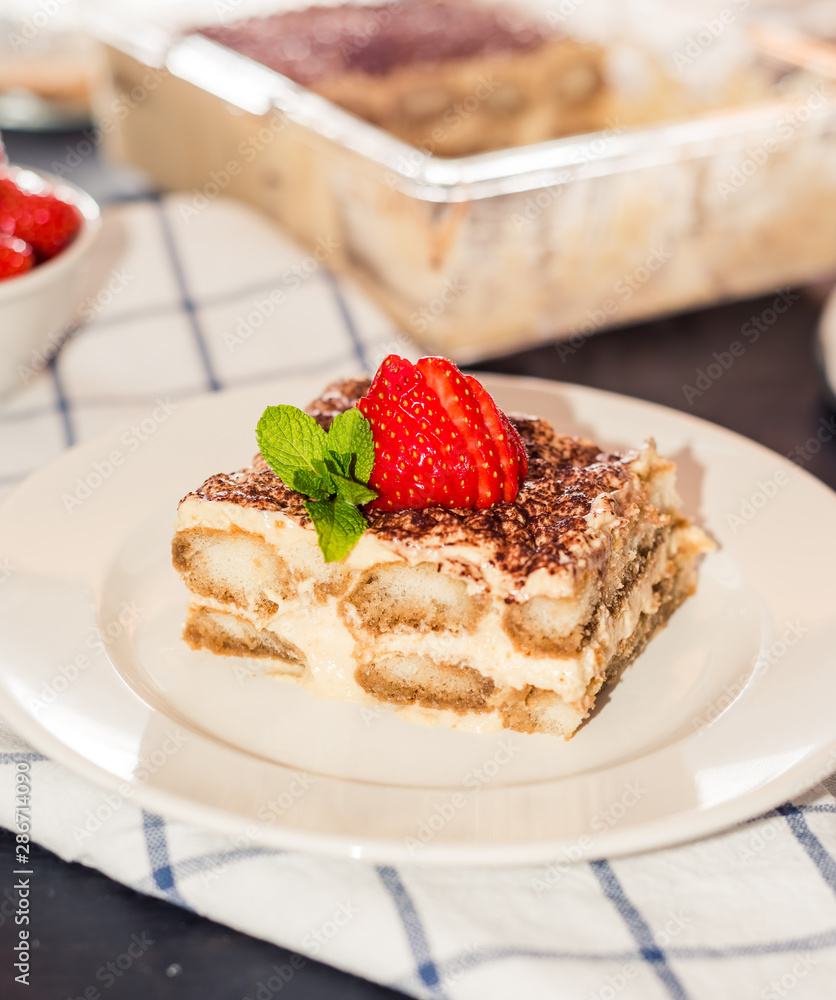 gourmet tiramisu dessert with strawberries in a beautiful plate on a dark background gourmet tiramisu dessert with strawberries in a beautiful plate on a dark background