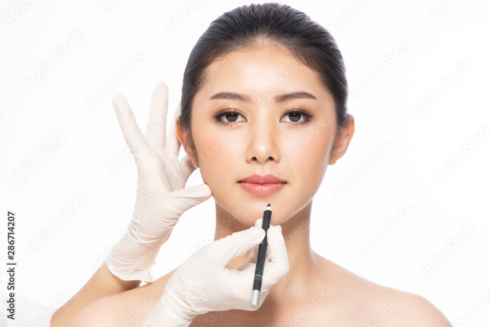 Lines on face, close up, plastic surgery concept, doctor's hand in glove making marks on patient's face..Asian beauty Woman in beauty salon. plastic surgery clinic. Lines on face, close up, plastic surgery concept, doctor's hand in glove making marks on patient's face..Asian beauty Woman in beauty salon. plastic surgery clinic.