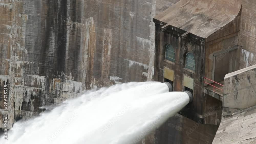 Slow motion shot of water being jet out of dam from enormous pipes. Water at high pressure to produce electricity. Detail of hydroelectric dam. Cordoba, Argentina Slow motion shot of water being jet out of dam from enormous pipes. Water at high pressure to produce electricity. Detail of hydroelectric dam. Cordoba, Argentina