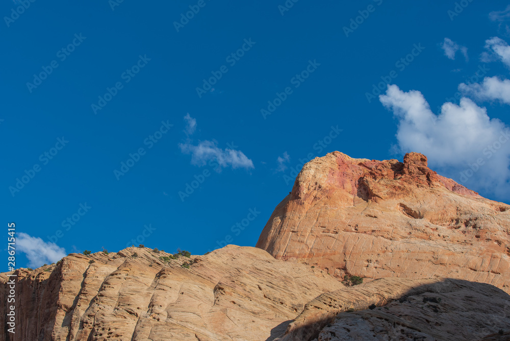 Capitol Reef National Park low angle landscape of massive stone mountain top against the sky