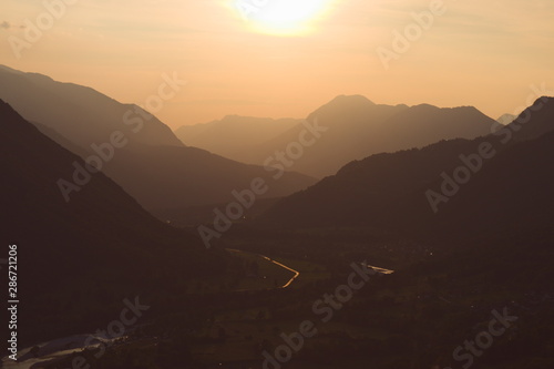 Sunset over layers of misty foggy mountains valley river