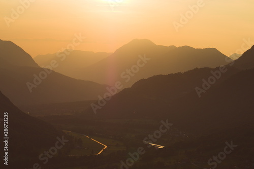 Sunset over layers of misty foggy mountains valley river
