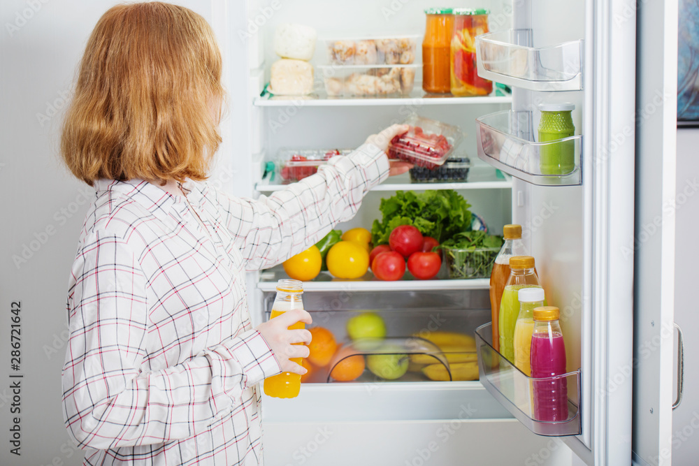 teenager girl at fridge with food