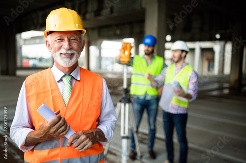 Fotografie Engineer, foreman and worker discussing in building construction site