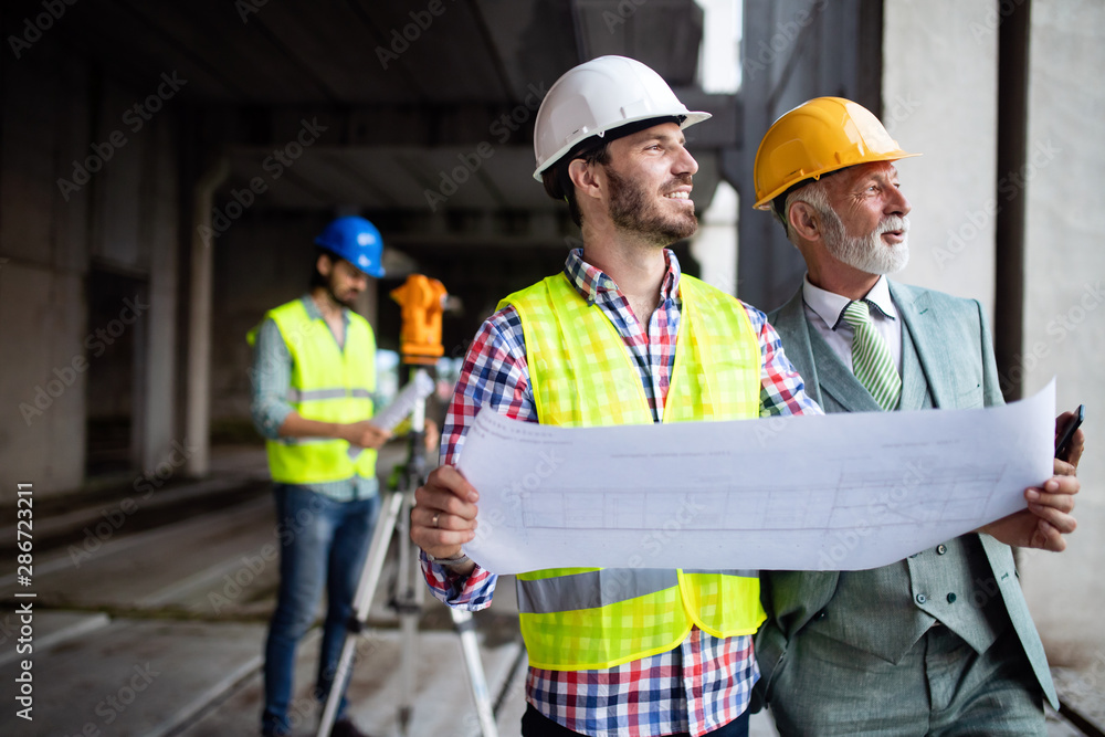 Engineer, foreman and worker discussing in building construction site Engineer, foreman and worker discussing in building construction site