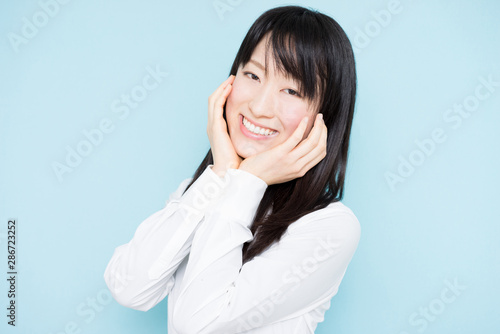 Happy business woman against light blue background © blanche