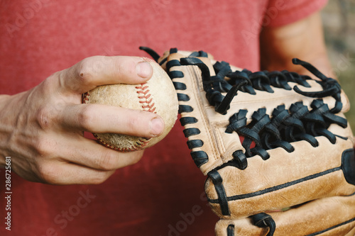 Baseball in hand with glove close up for team player recreation, american sport.