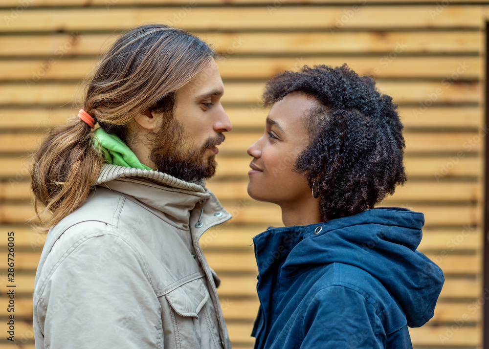 guy with an african american girl in love in autumn park walk at sunset guy with an african american girl in love in autumn park walk at sunset