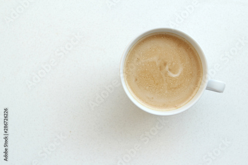 white wide cup of coffee, cappuccino with milk, cocoa on a white table, top view, save space