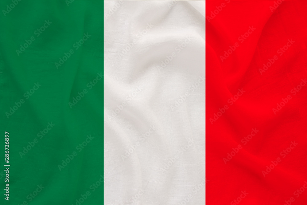The national flag of the country of Italy on gentle silk with wind folds, travel concept, immigration, politics, copy space, close-up