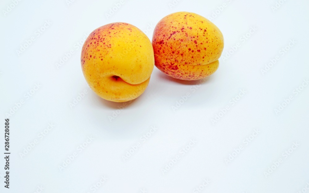Delicious juicy apricots are located on a white background Delicious juicy apricots are located on a white background