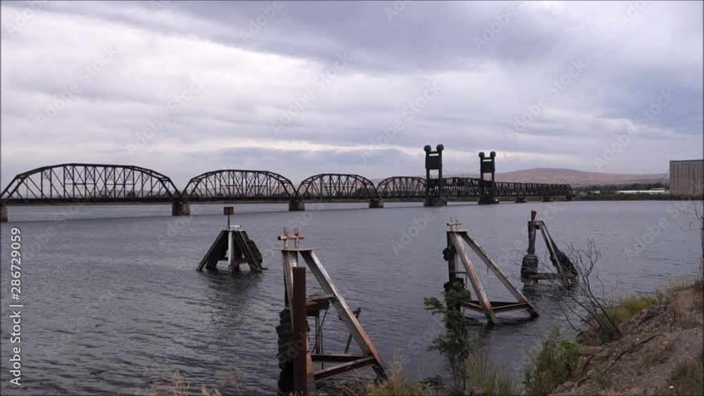 railroad bridge over river on cloudy day railroad bridge over river on cloudy day