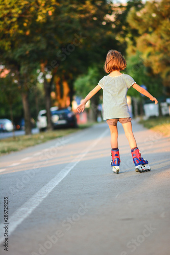 Wallpaper Mural Little girl successfully learns to roller skate. Young girl learns to rollerblade. Torontodigital.ca