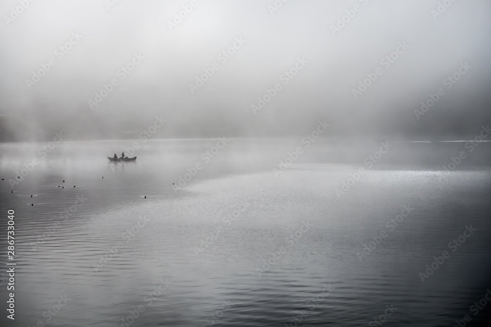 Fototapeta premium Fishing in the morning fog on the lake in japan